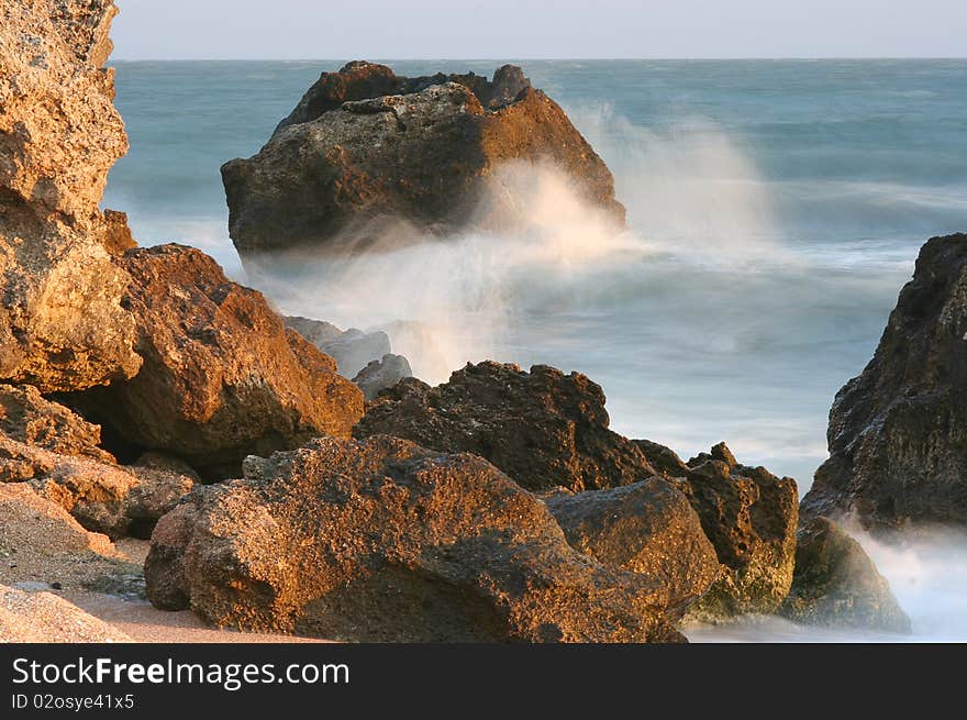 Stones and sea surf are shined by the morning sun. Stones and sea surf are shined by the morning sun