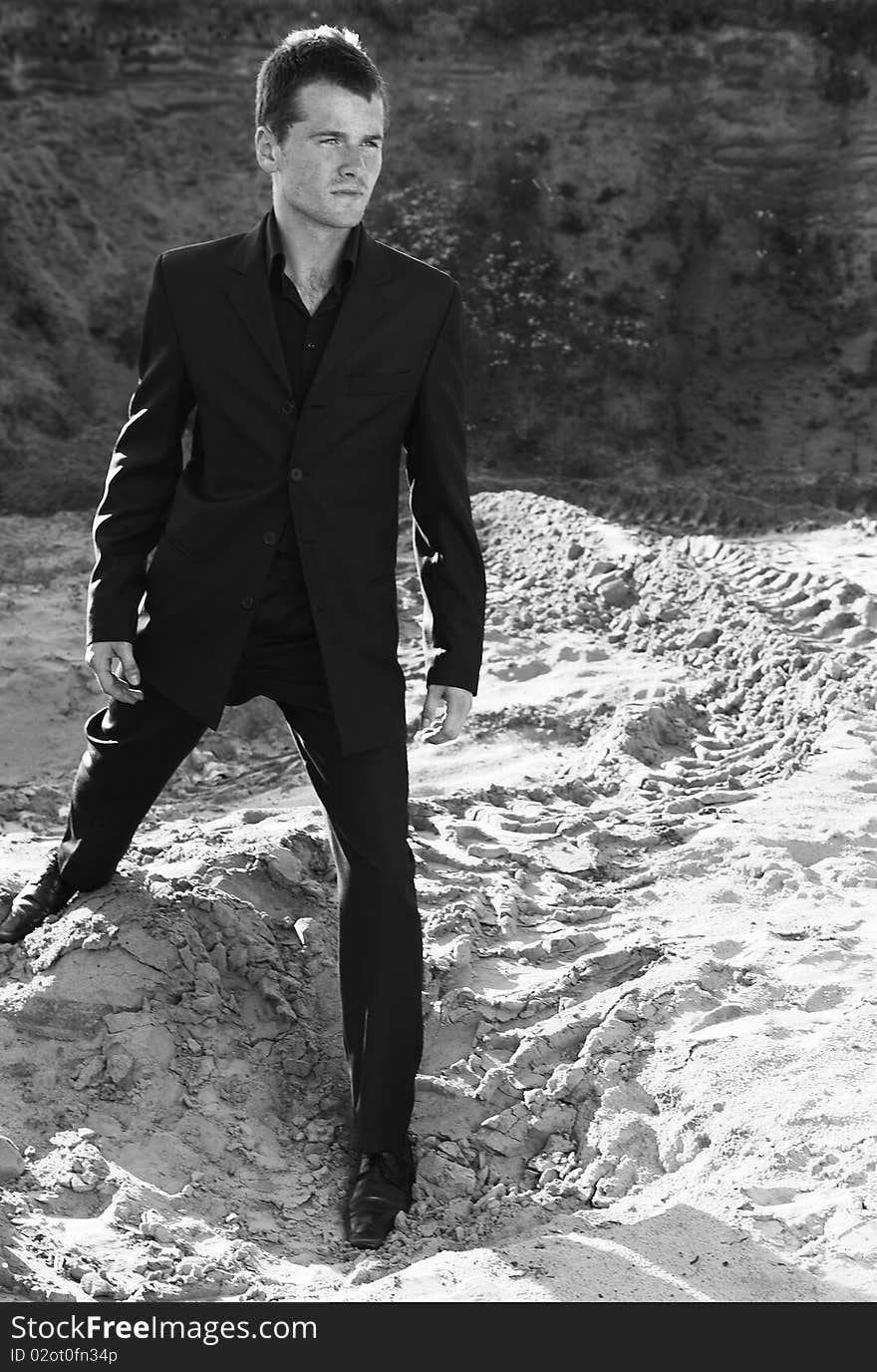 Man in elegant suit in open-cast mine. Black&White photo.