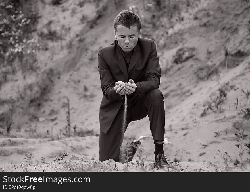 Man in elegant suit in open-cast mine.