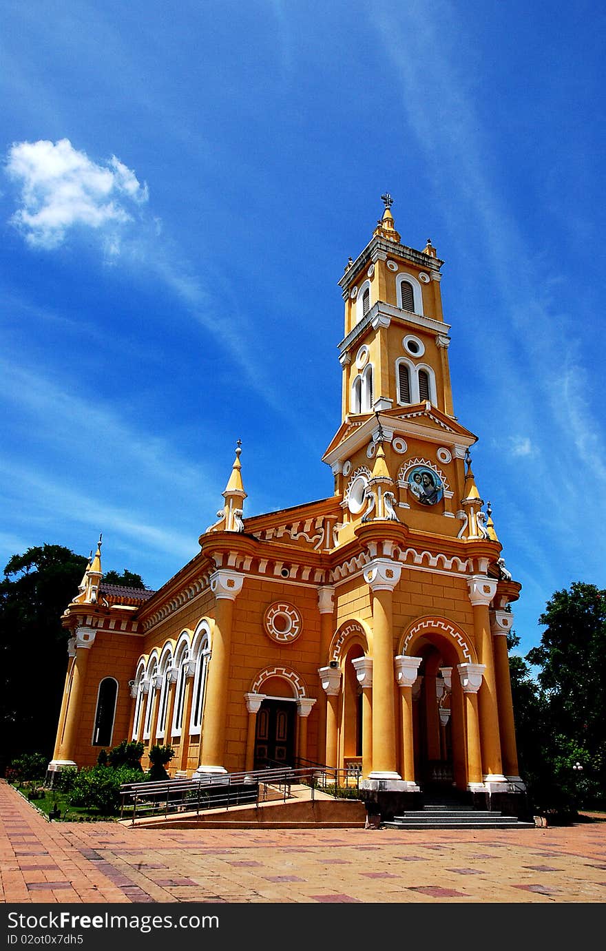 Yellow church with tree in summer