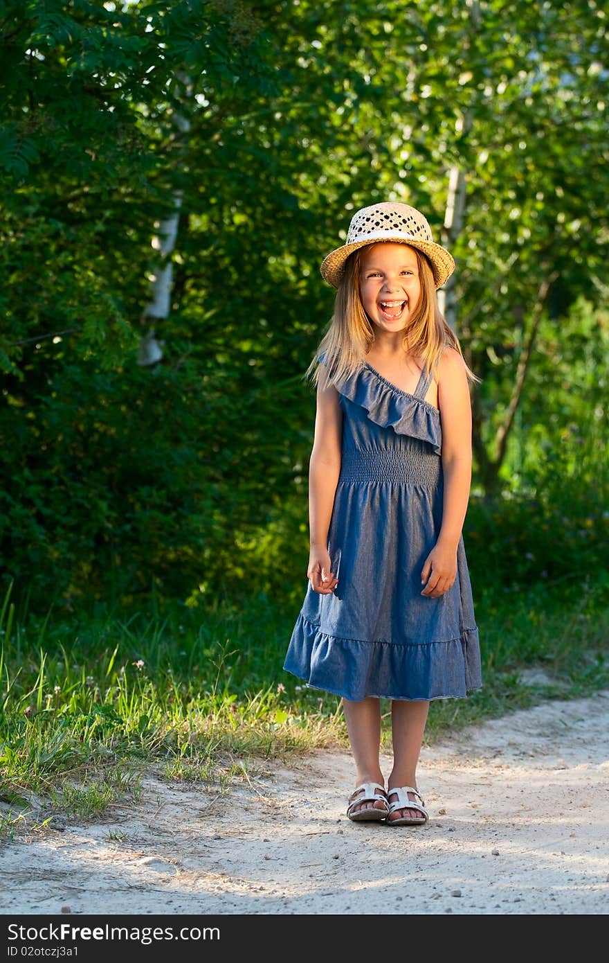 Laughing beautiful girl stand at the rural road in the jeans dress. Laughing beautiful girl stand at the rural road in the jeans dress.