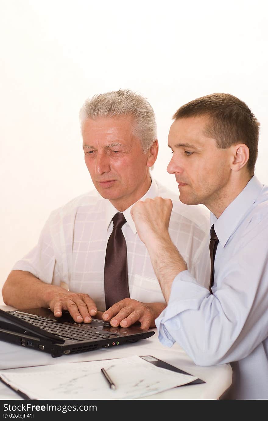 Two businessmen working together on a white