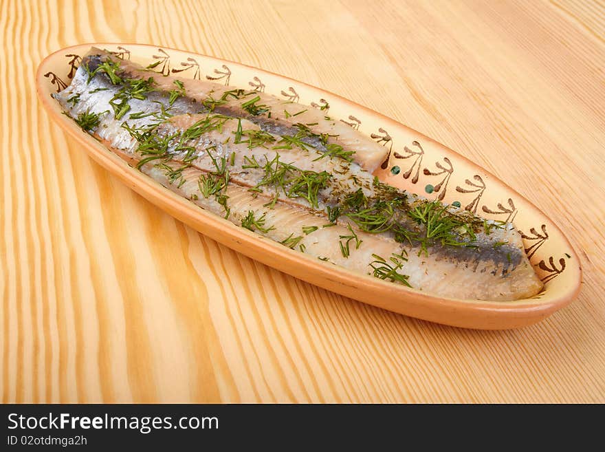 Herring on  plate on wood board