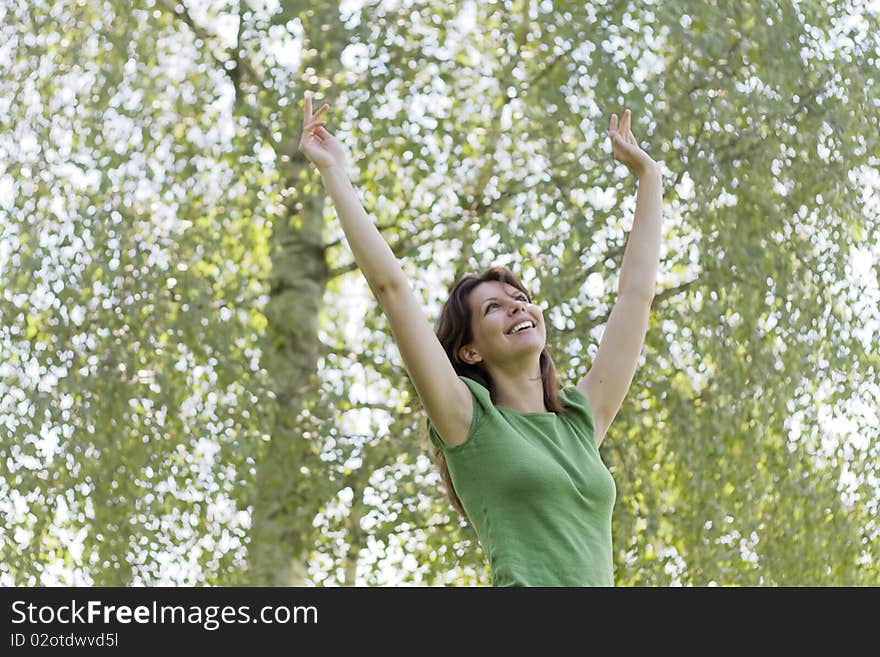 Young woman arms raised enjoying the nature. Young woman arms raised enjoying the nature