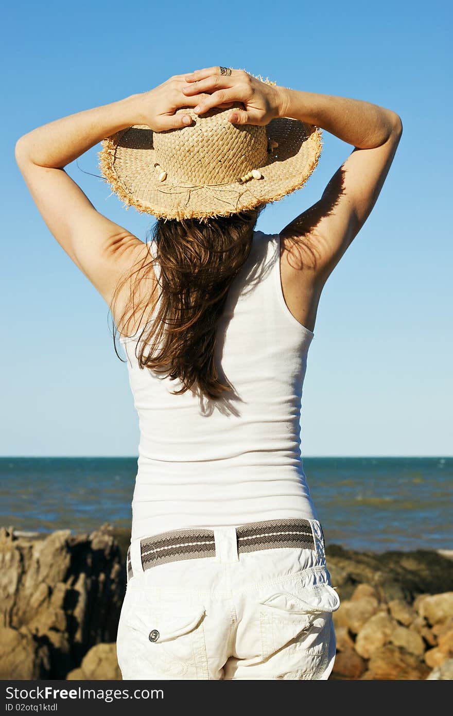 Beautiful young woman relaxing by the ocean