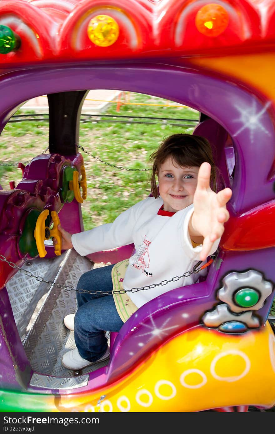 Little girl in a colorful train in the park. Little girl in a colorful train in the park.