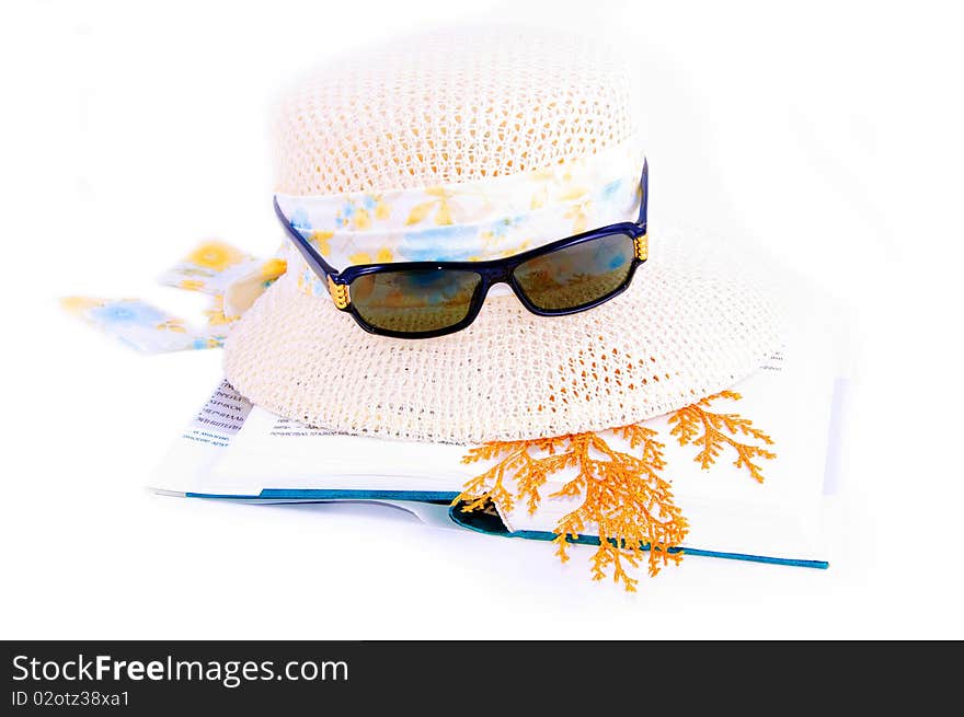 A set of lady's hat book and sunglasses isolated over white. A set of lady's hat book and sunglasses isolated over white