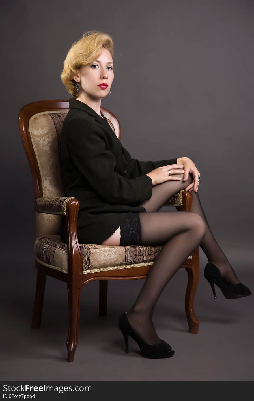 Woman in a business suit sits in an armchair