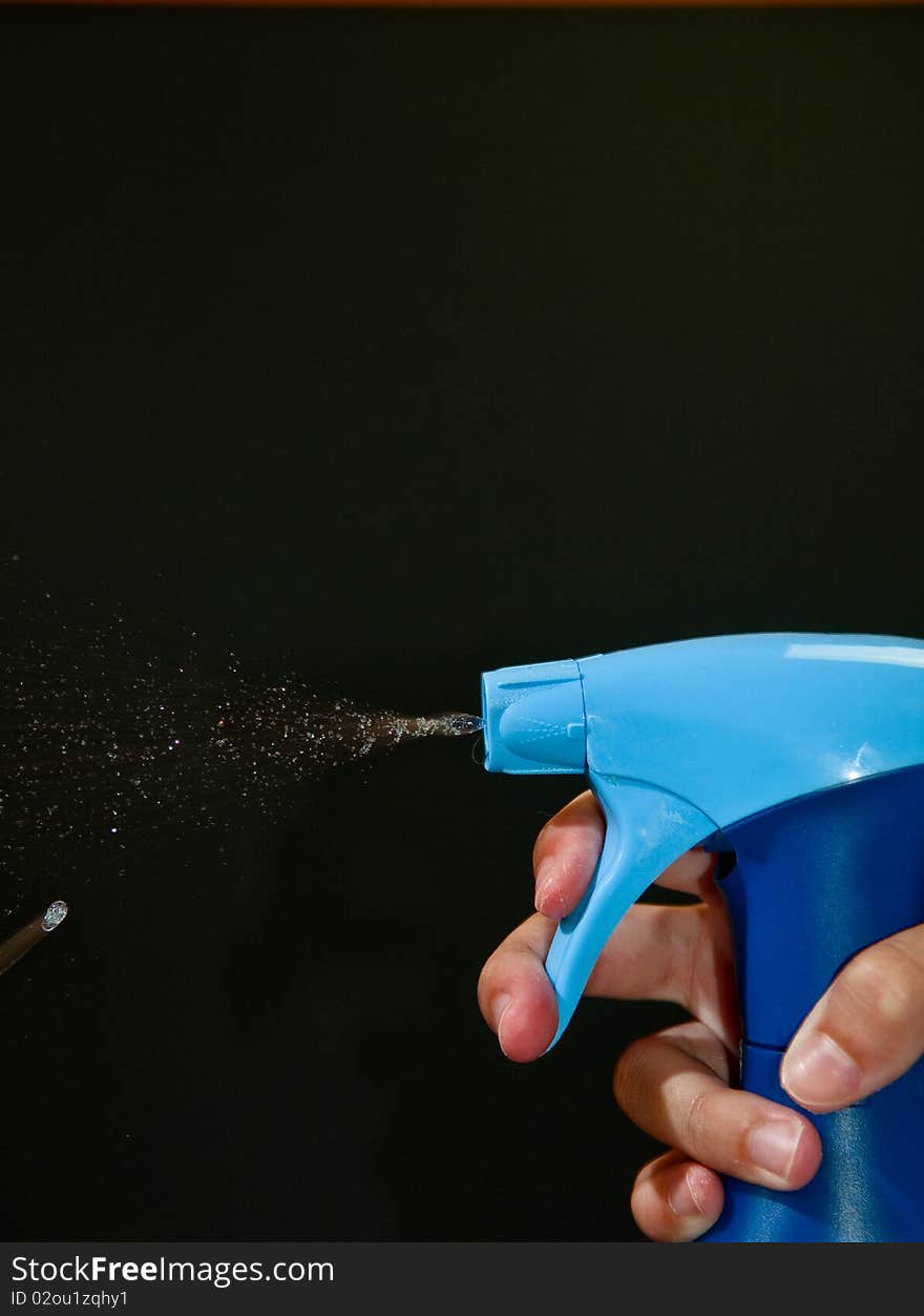 A bottle of disinfectant spraying isolated on black. A bottle of disinfectant spraying isolated on black