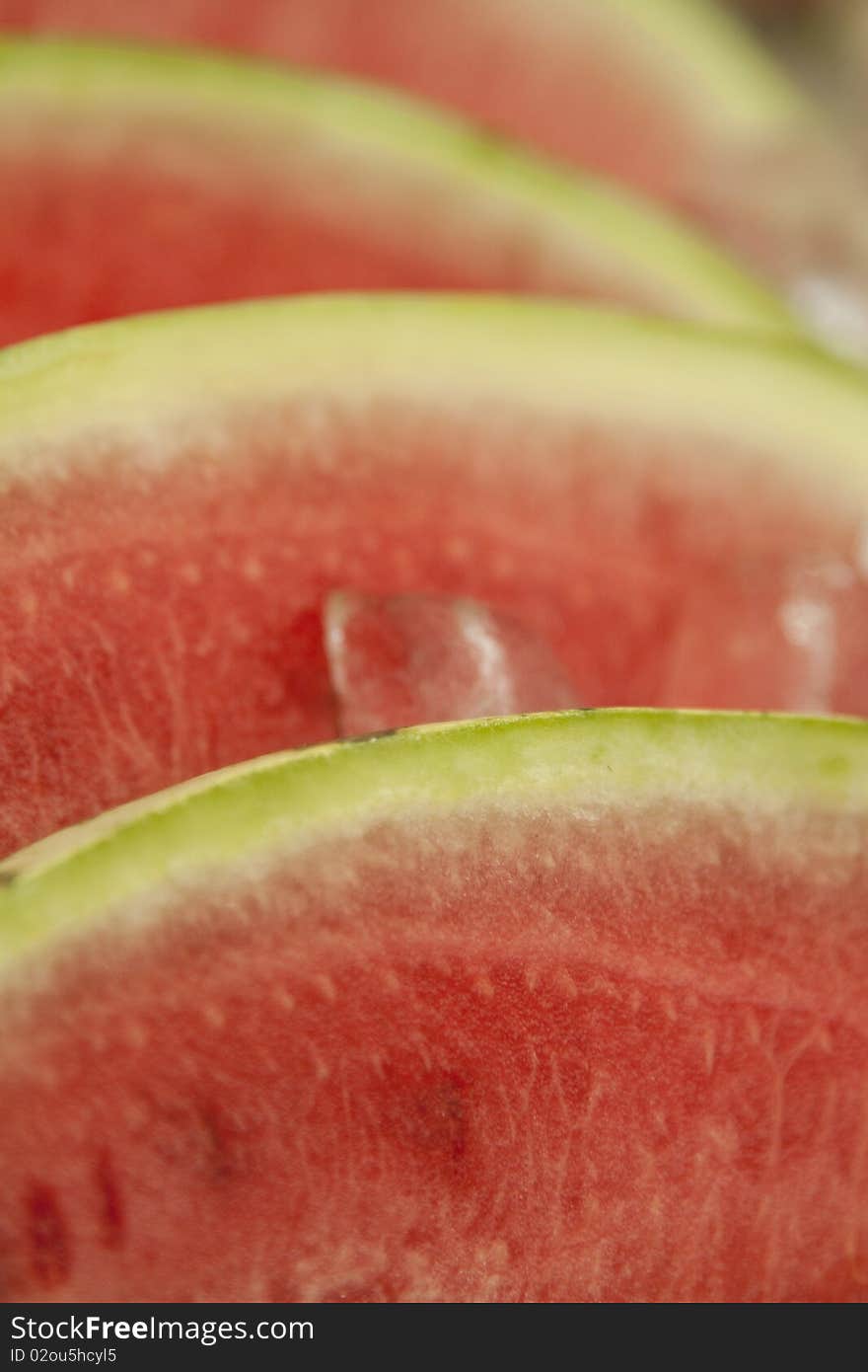 Stack of watermelon slices kept cool in ice at summer market. Stack of watermelon slices kept cool in ice at summer market