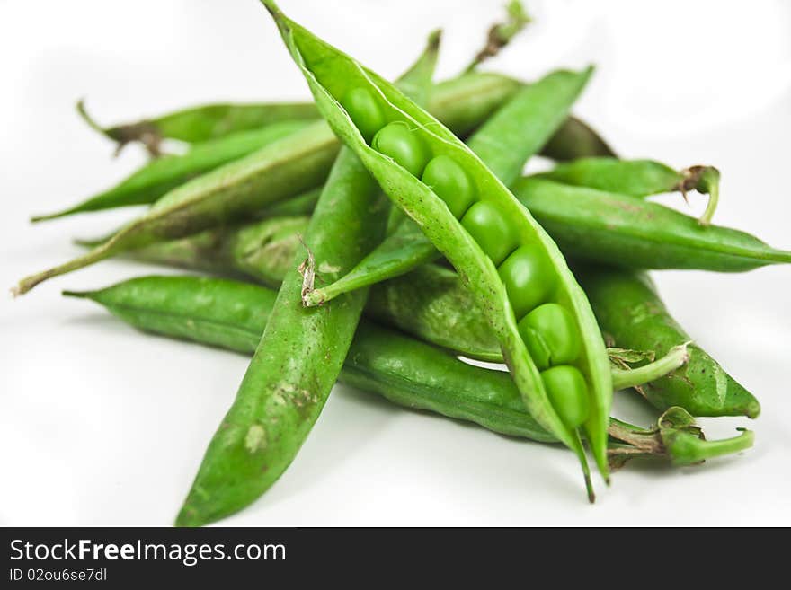 Shallow depth of field studio shot on white background of peas in their pod. Shallow depth of field studio shot on white background of peas in their pod