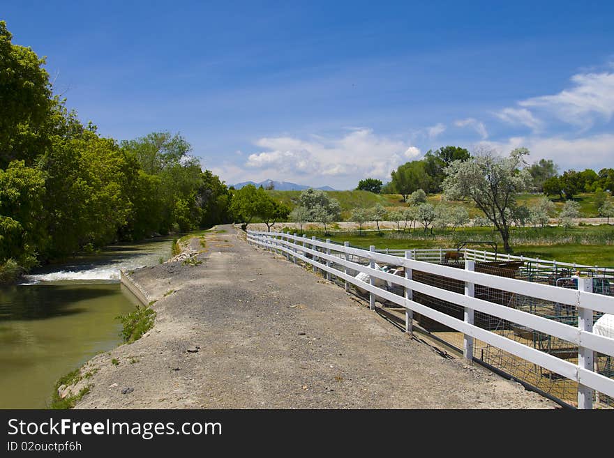 Urban scene of a country road along side a farm and flowing stream. Urban scene of a country road along side a farm and flowing stream