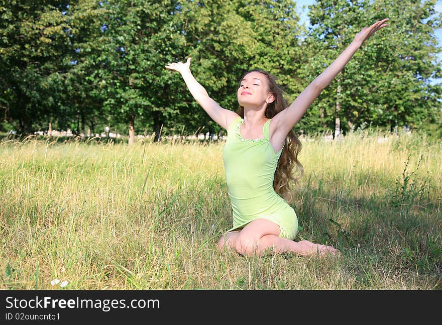 Beautiful blond girl sitting on the grass in the park and enjoy nature and freedom. Beautiful blond girl sitting on the grass in the park and enjoy nature and freedom