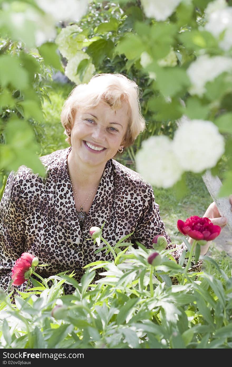 Portrait of relaxed senior woman in a blossoming garden. Portrait of relaxed senior woman in a blossoming garden