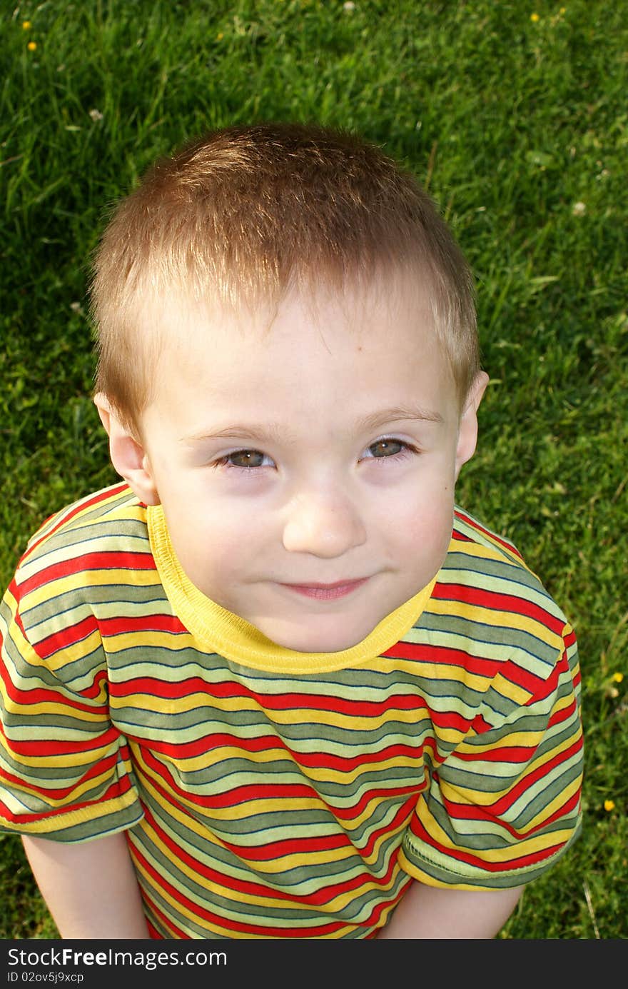 The child looks up, portrait, the background grass