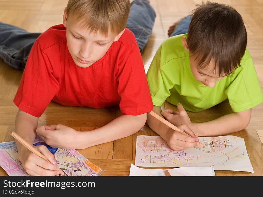 Two brothers lying on the floor and draw. Two brothers lying on the floor and draw