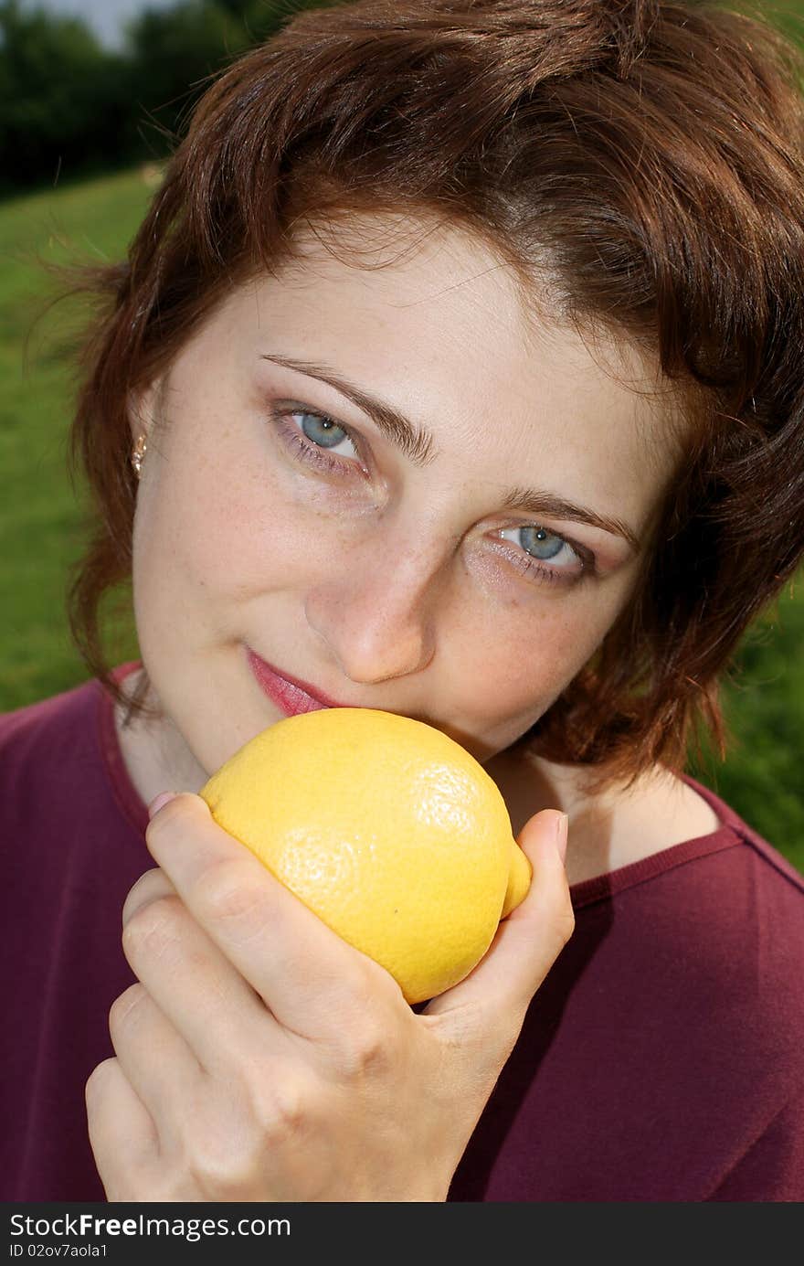 A beautiful girl is holding a lemon