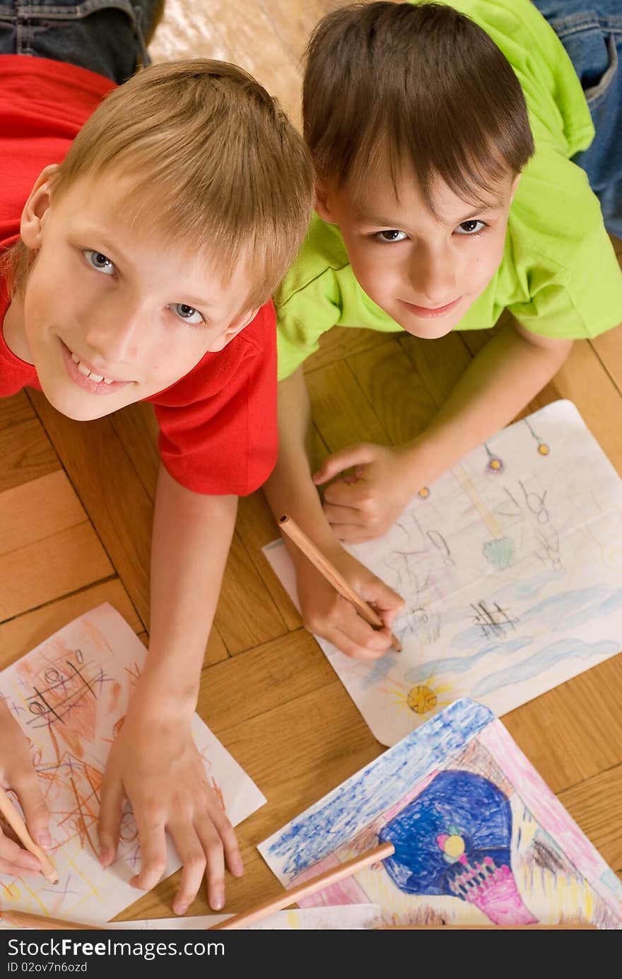 Two brothers lying on the floor and draw. Two brothers lying on the floor and draw