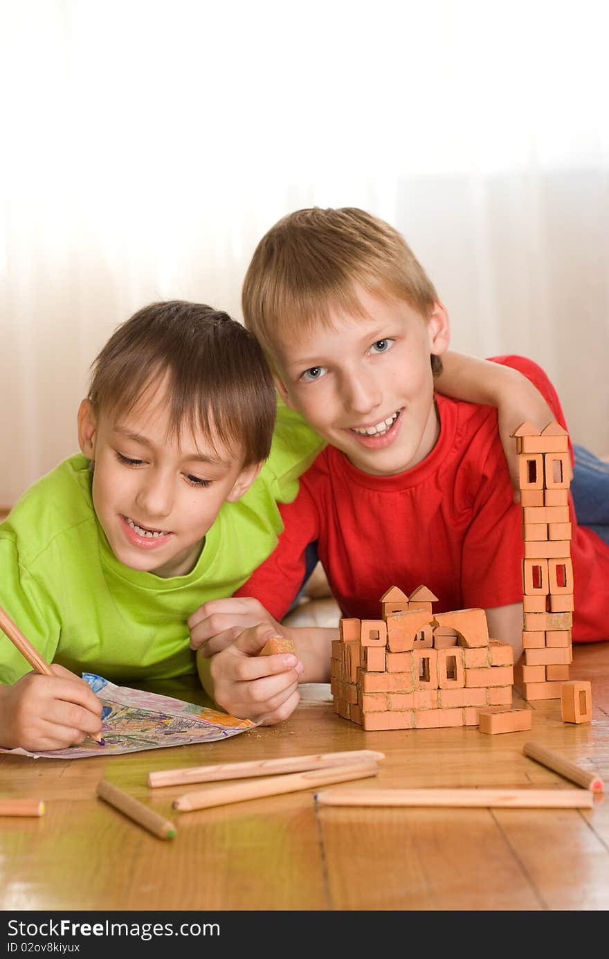 Two brothers lying on the floor and draw. Two brothers lying on the floor and draw