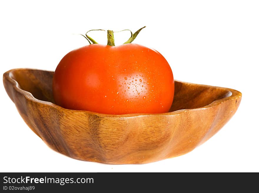 Tomato in wooden bowl isolated on white background