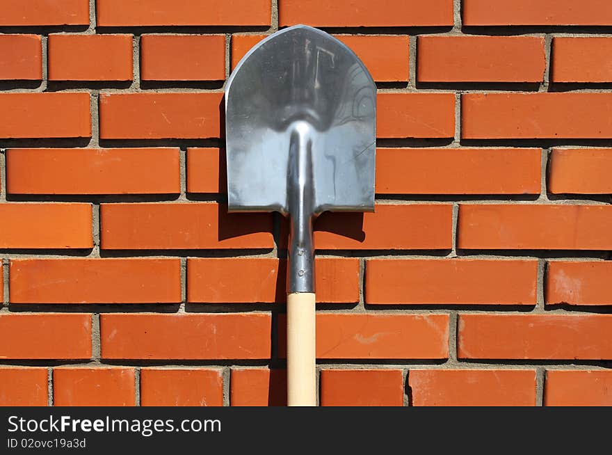 Spade standing at a wall in a garden