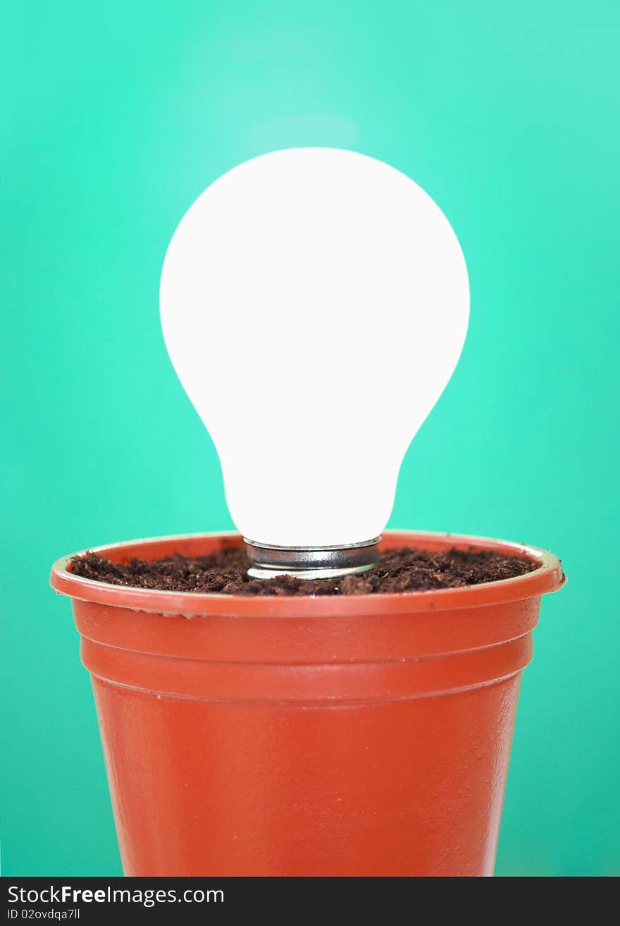 Lit light bulb in a pot with soil. Lit light bulb in a pot with soil