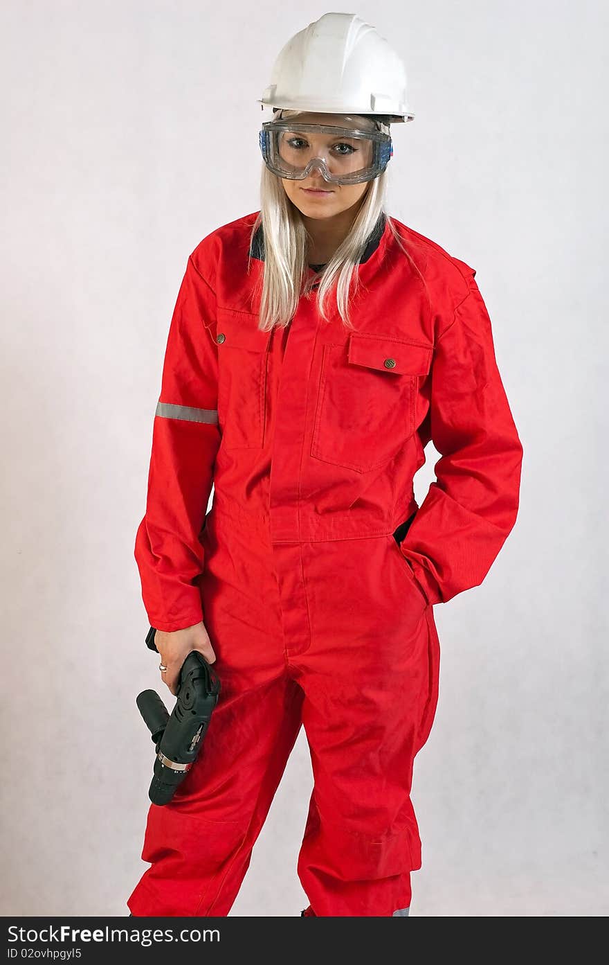 Young woman builder in white helmet holding driller. Young woman builder in white helmet holding driller