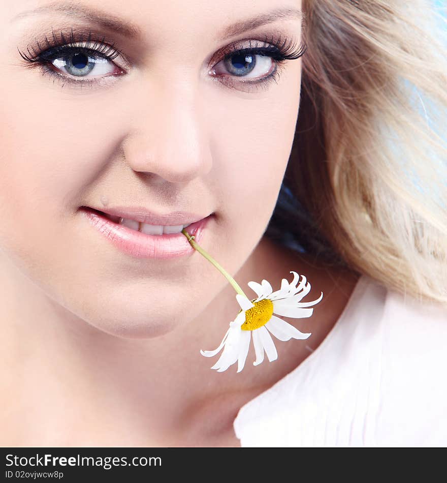 Close-up portrait of a fresh and beautiful woman with camomile.