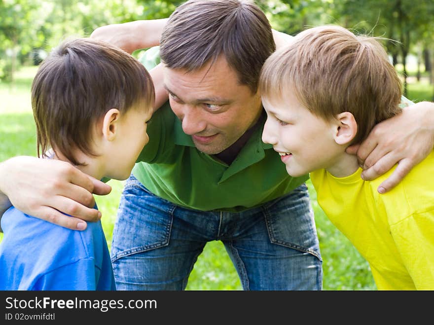 Dad plays with young children outdoors