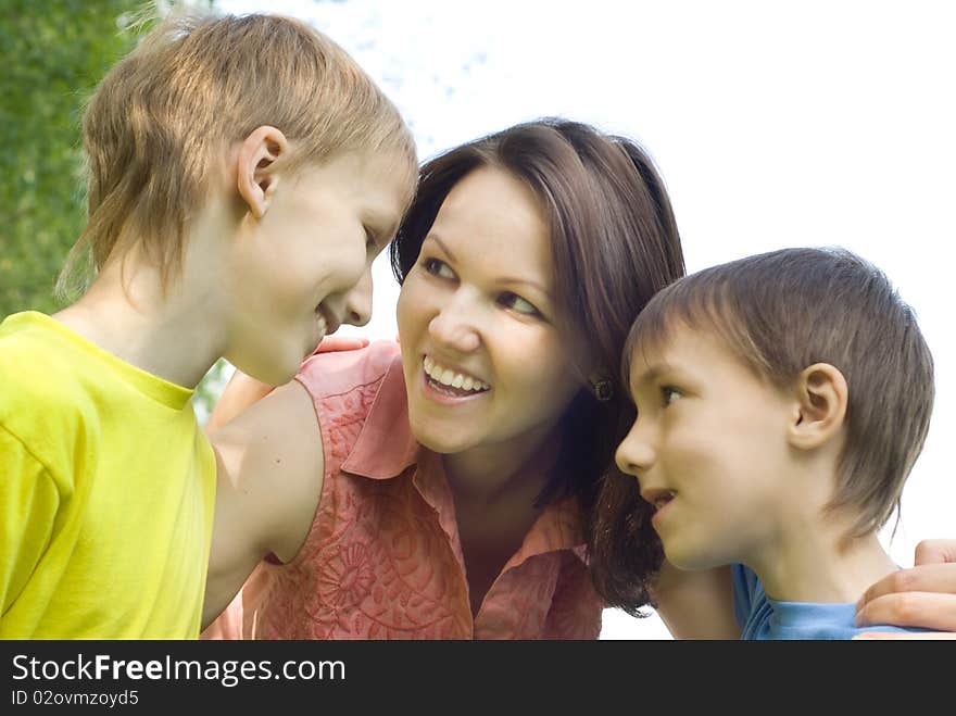 Happy boys with mom in the summer park