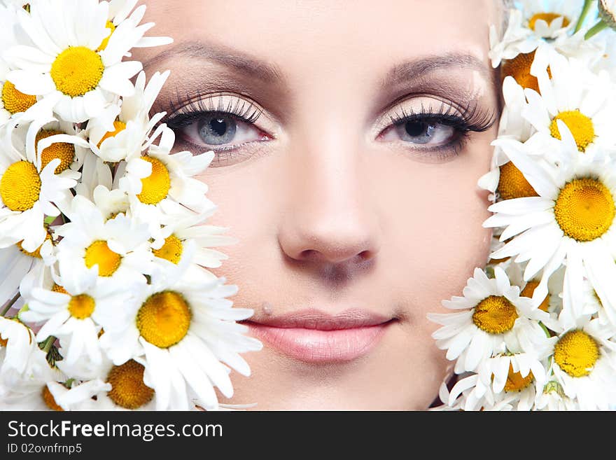 Close-up portrait of a fresh and beautiful woman with camomile.