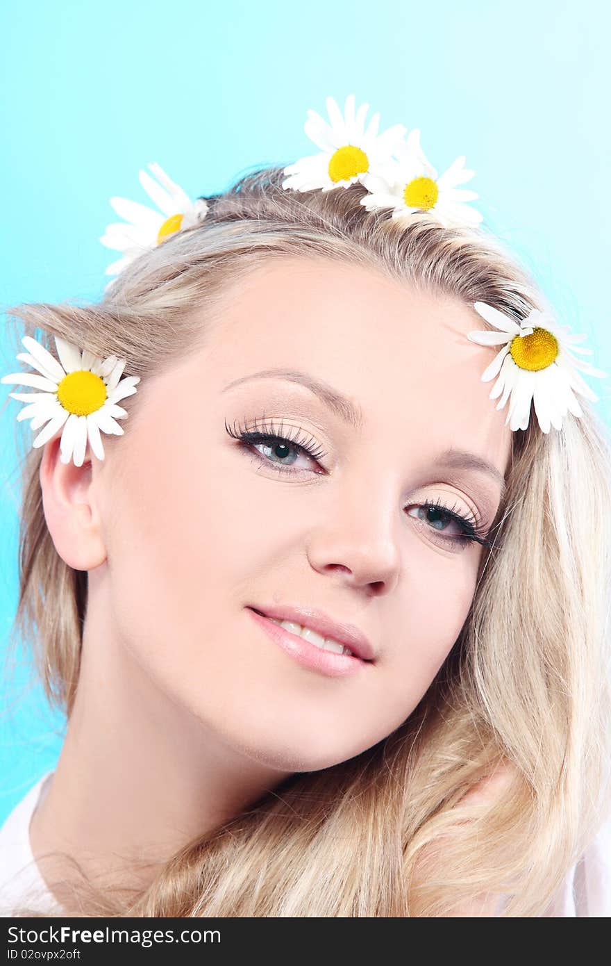 Close-up portrait of a fresh and beautiful woman with camomile.