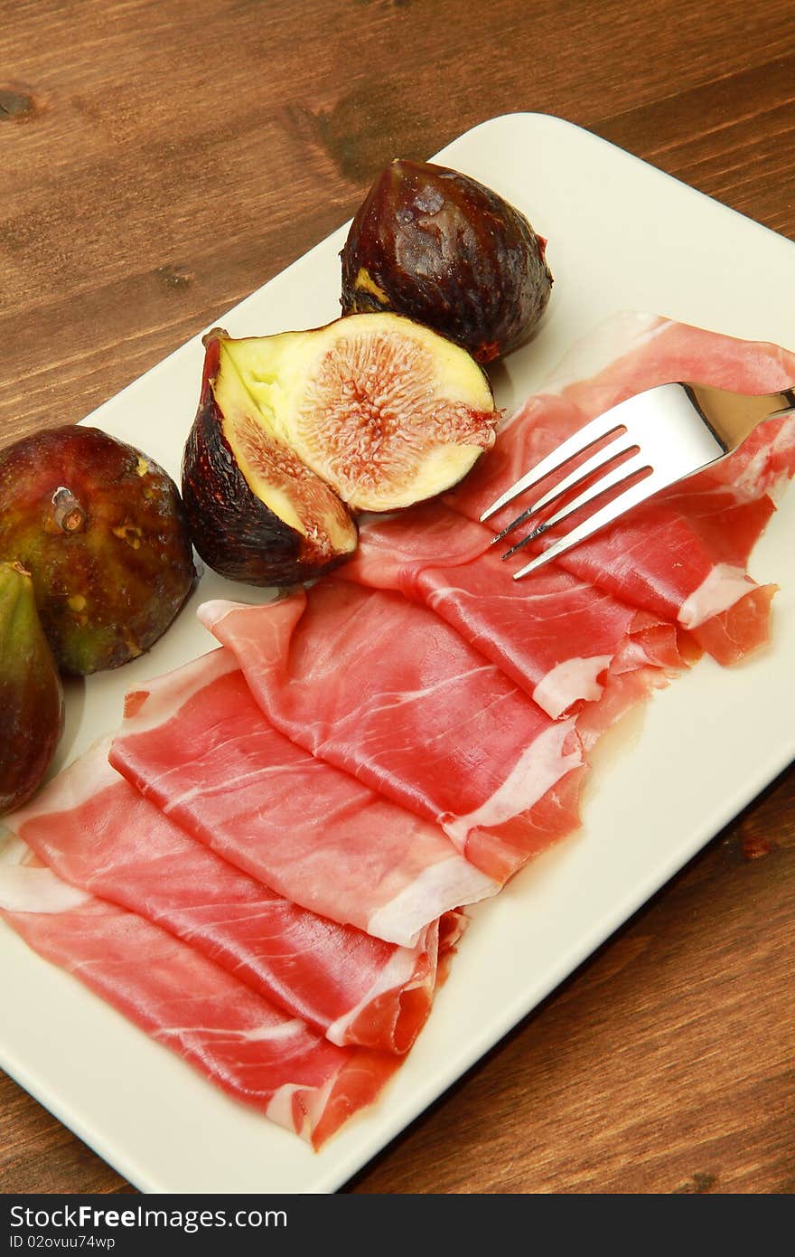 A dish with fresh fig with ham