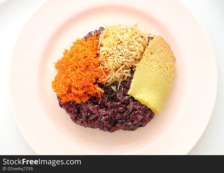 Thai style sweet desserts. Three type on glutinous rice, Sang ka ya (made from eggs and coconut milk), shred coconut and sesame, shrimp (orange color).