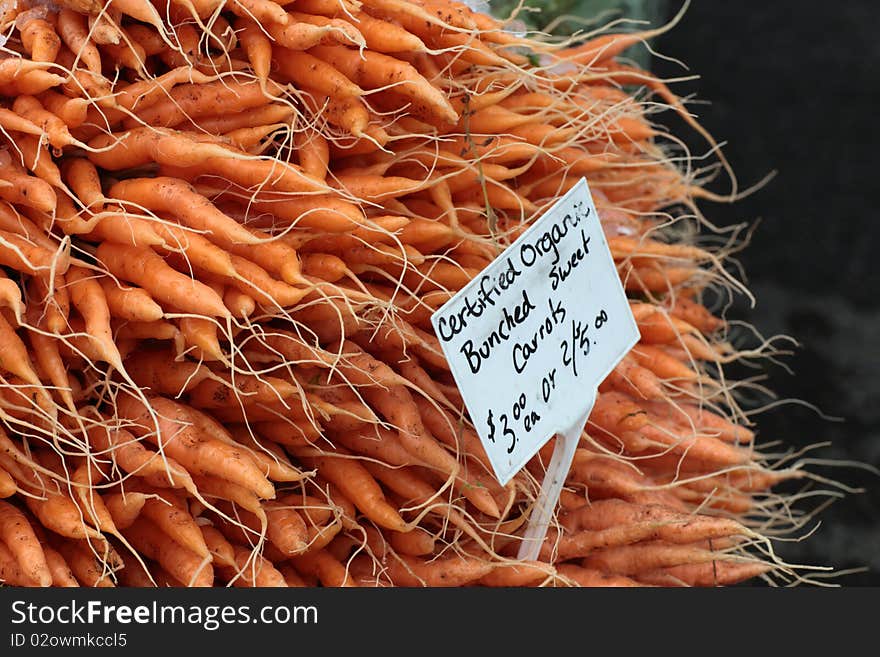 A mountain of fresh carrots at a farmer's market. A mountain of fresh carrots at a farmer's market.