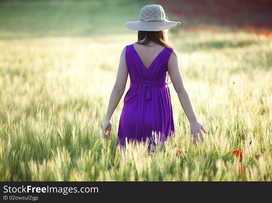 Young beautiful girl posing in a green field. Young beautiful girl posing in a green field.