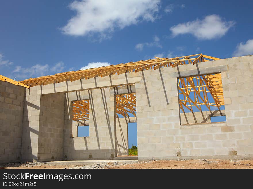 New Home Construction of a cement block home with wood roof trusses viewed from outside.