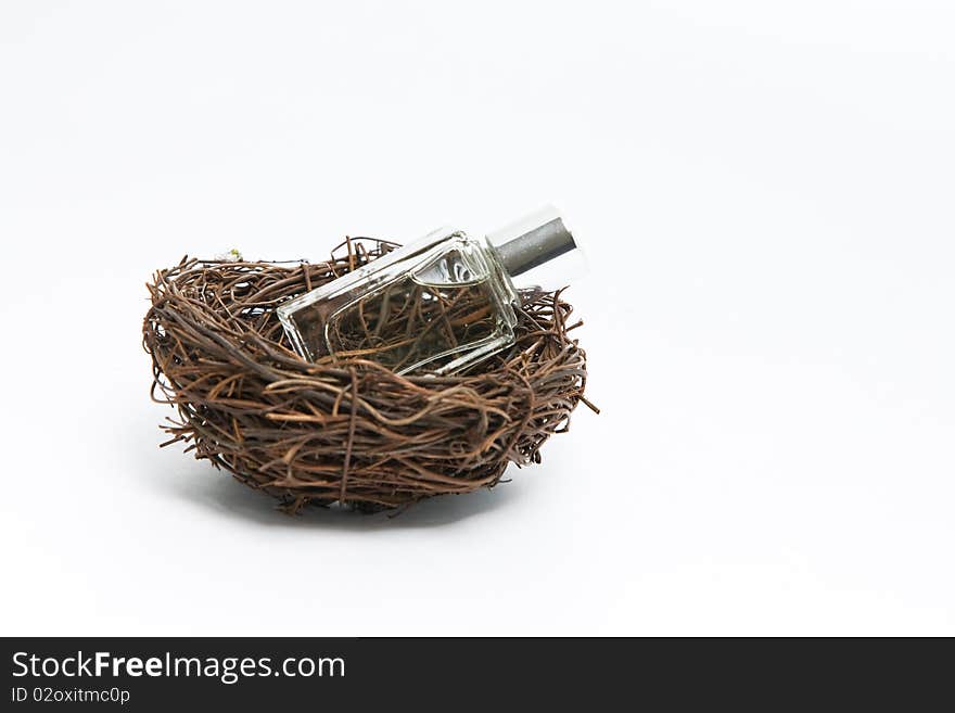 Fragrance bottle in a bird cage isolated on white. Fragrance bottle in a bird cage isolated on white