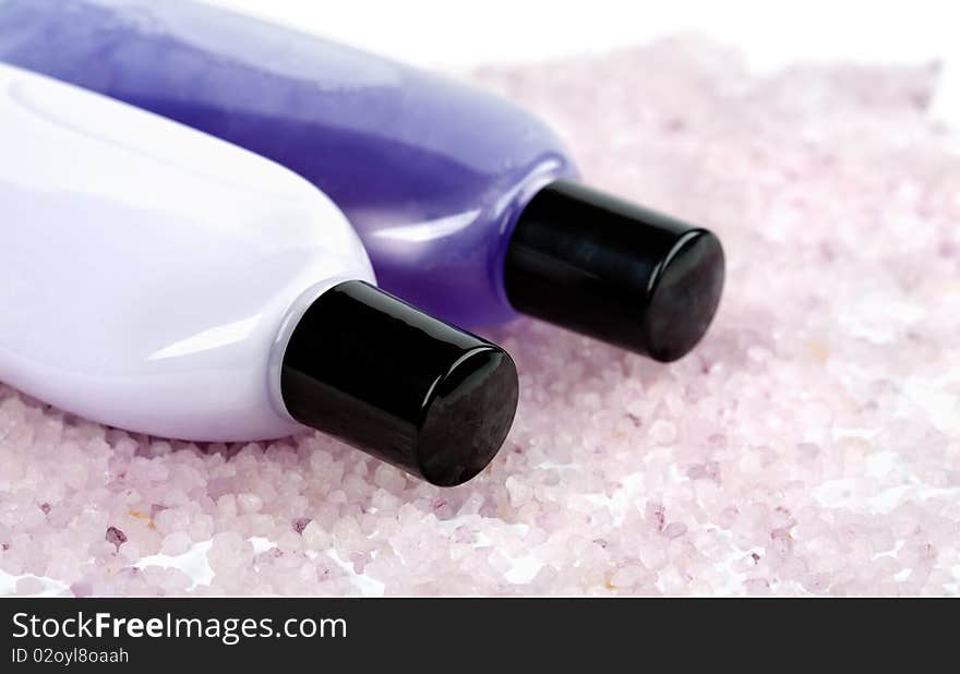 Spa and body care - herbal salt and cosmetic bottles with gel and lotion on white background