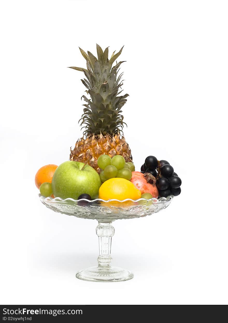 Group of different fruits in a glass vase on a white background. Group of different fruits in a glass vase on a white background