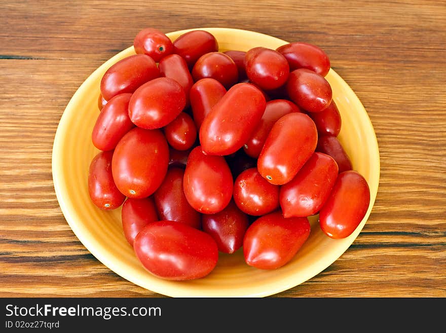 Plate full of tomatos in a yellow plate on a table