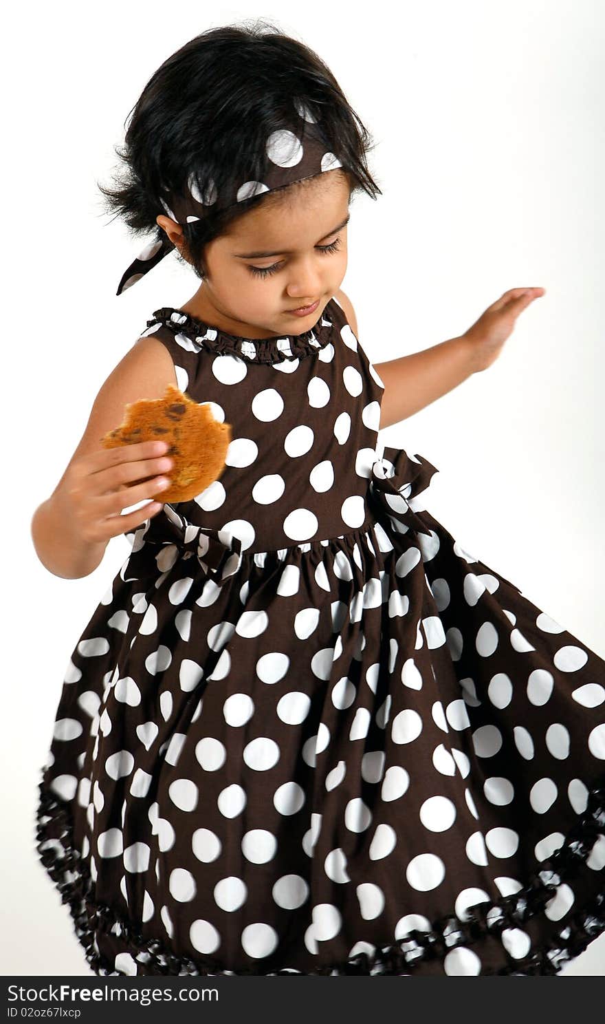 Sweet and cute toddler eating chocolate chip cookie and enjoying