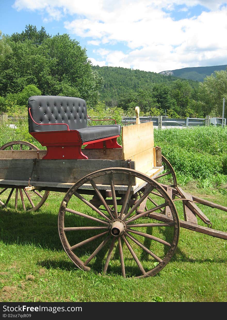 An old buckboard sits in a field as if it just got back from a ride.