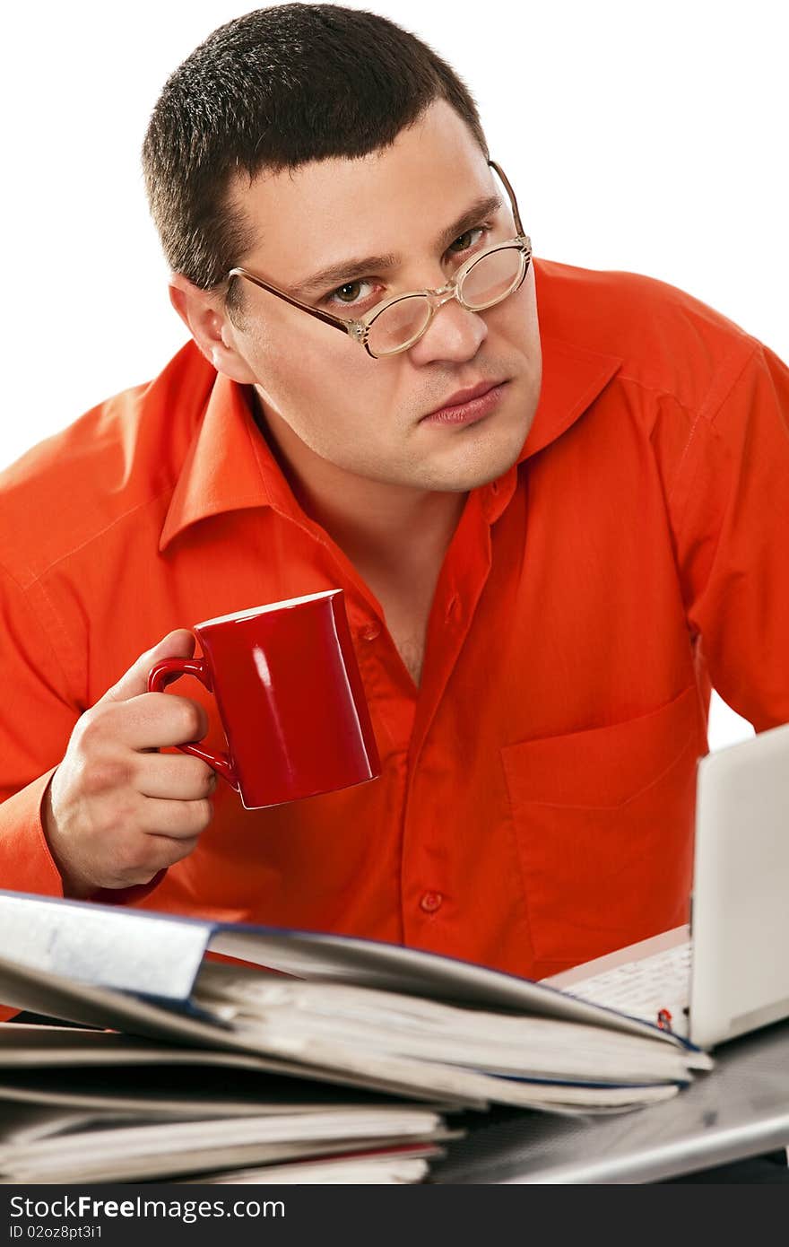 Funny businessman surrounded by files drinking coffe