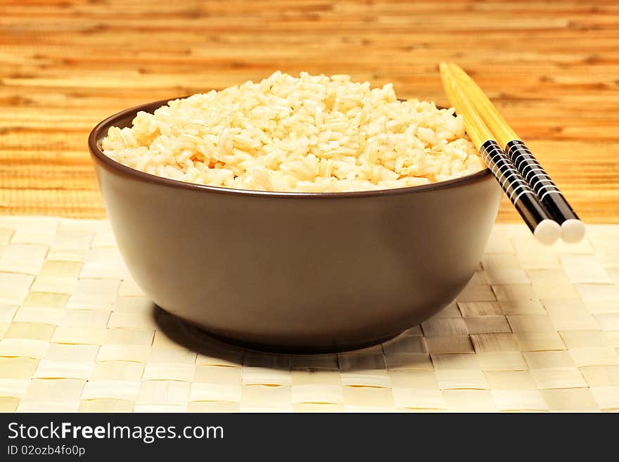 Steamed long rice in a brown bowl with chopsticks. Steamed long rice in a brown bowl with chopsticks.