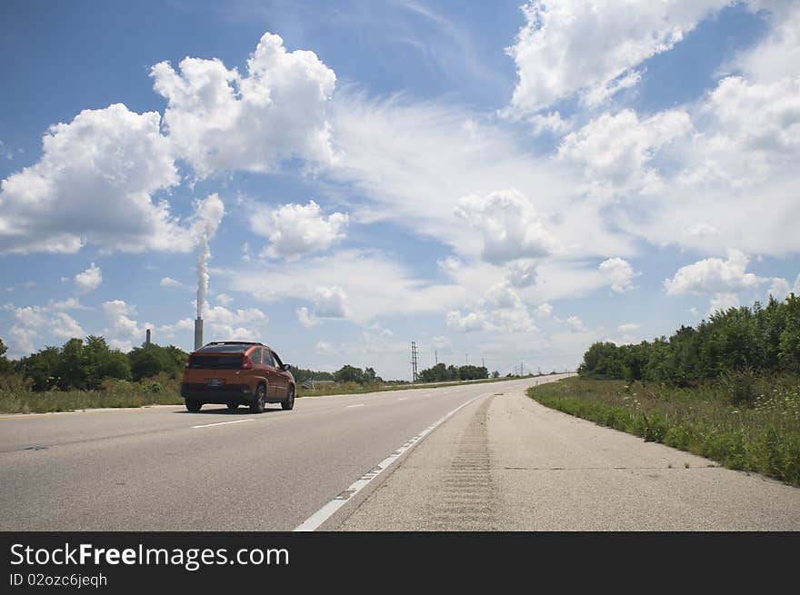 Open roadway blue skyline with a single car. Open roadway blue skyline with a single car.