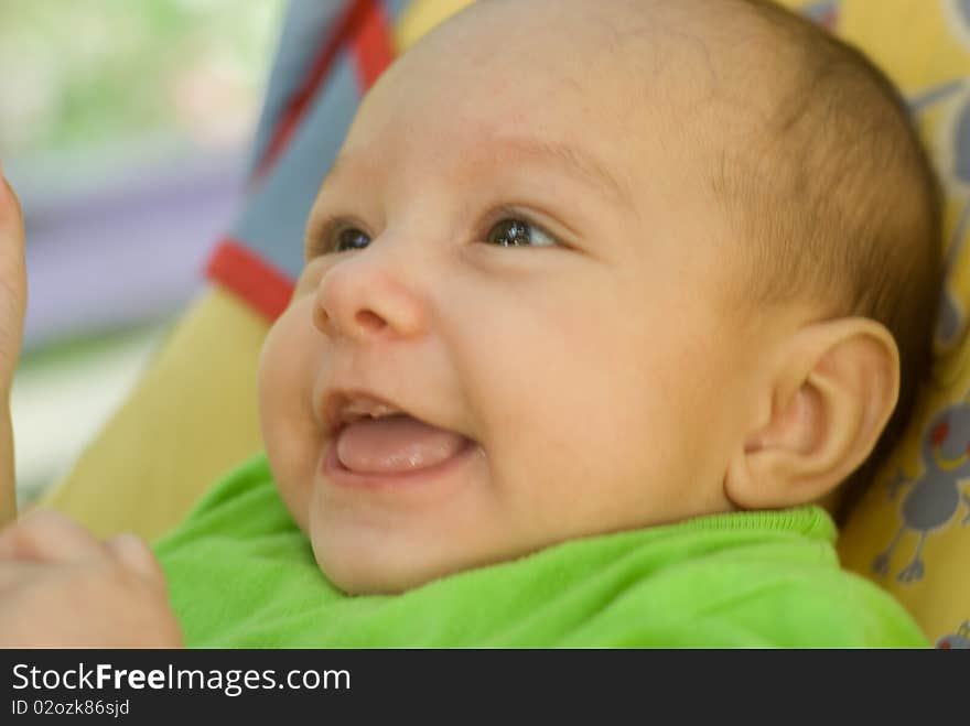 Happy newborn baby lies on a green background. Happy newborn baby lies on a green background