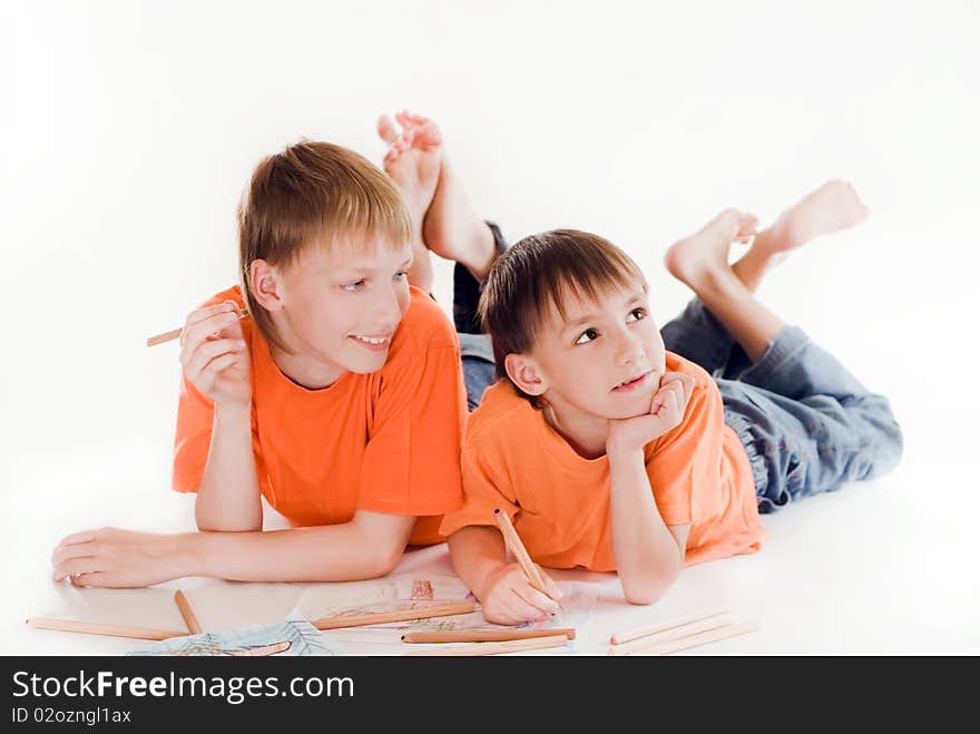 Happy brothers lying on the floor and draw. Happy brothers lying on the floor and draw