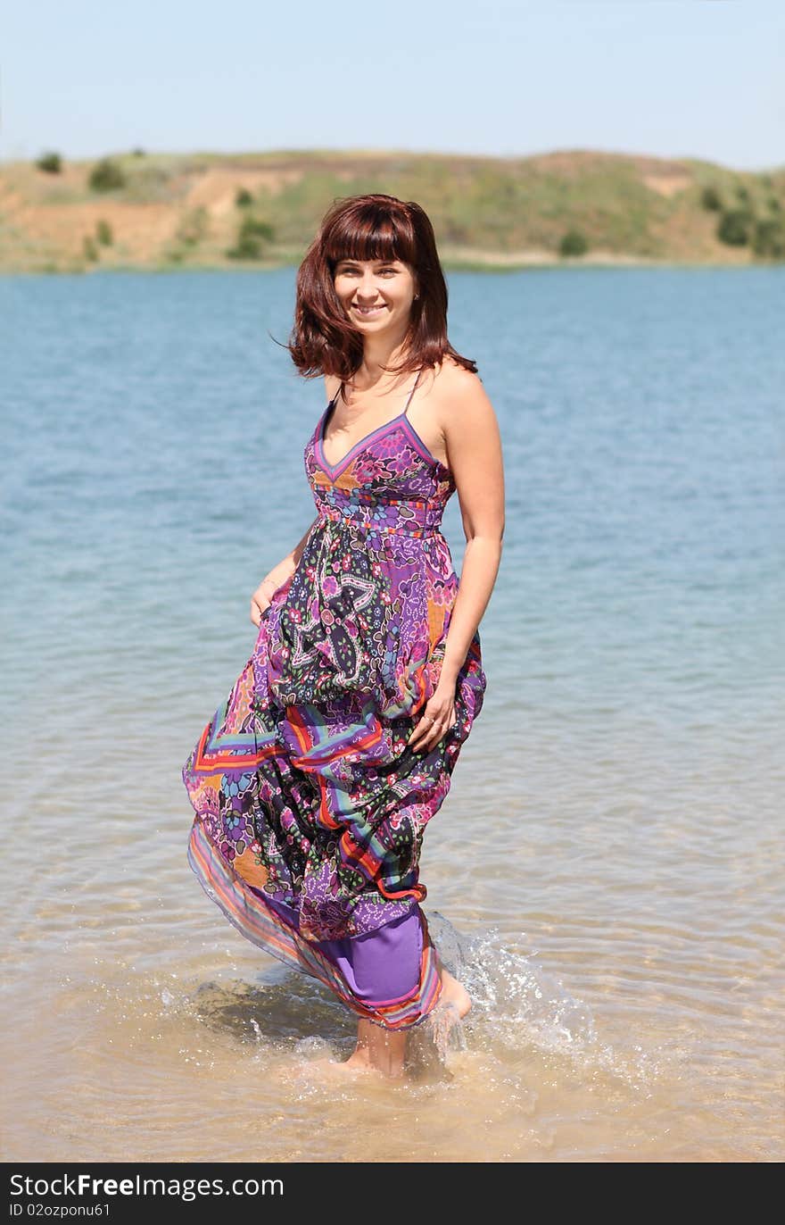 Happy brunette girl on the summer lake