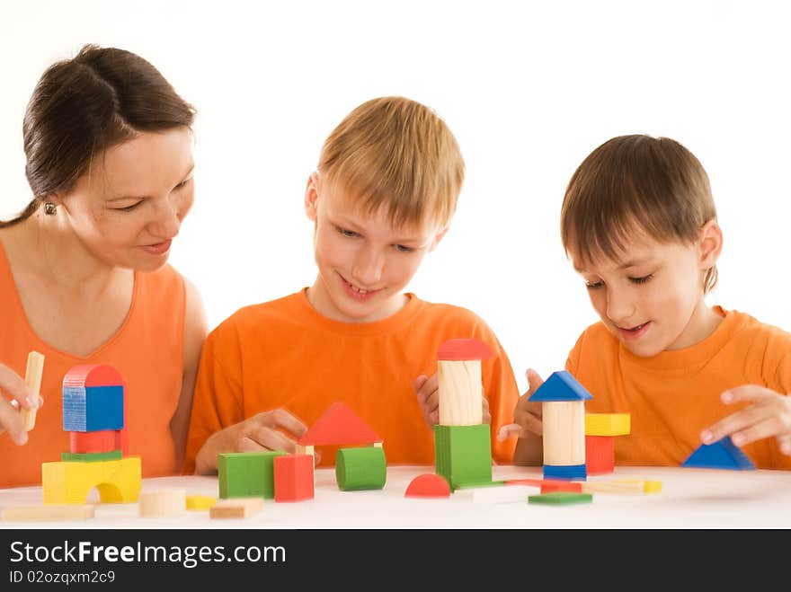 Young mother sitting at the table with two sons. Young mother sitting at the table with two sons